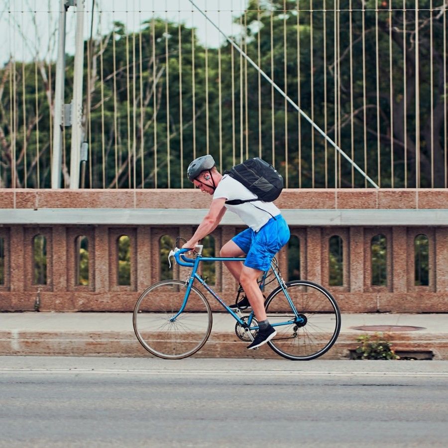 man-in-white-top-and-blue-shorts-driving-bicycle