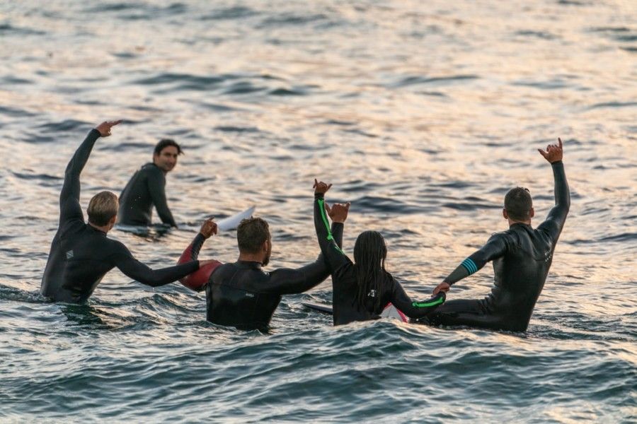 people-wearing-black-wetsuits-in-body-of-water