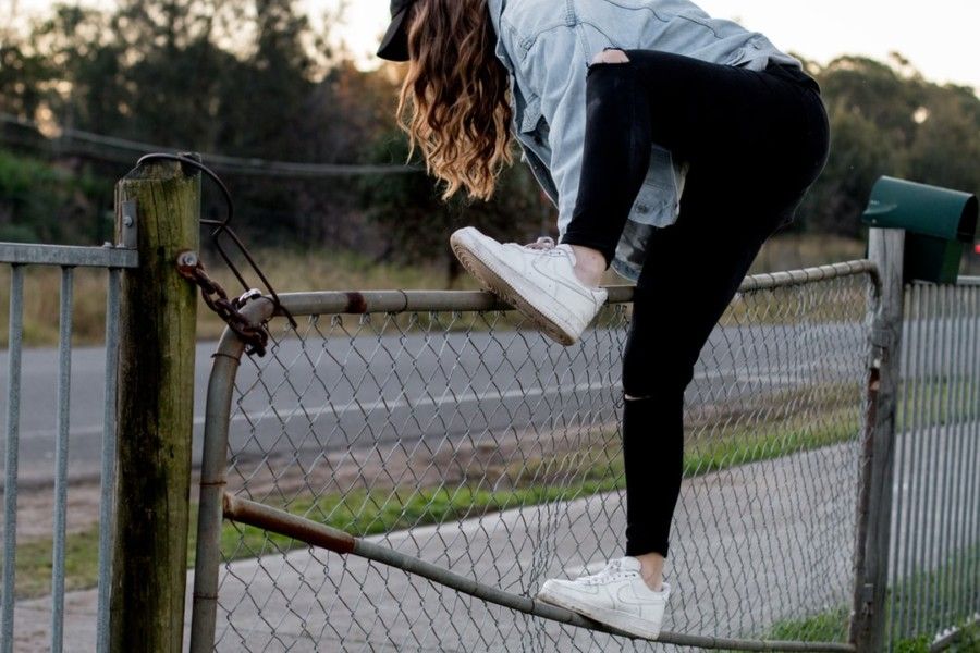 woman-climbing-over-fence