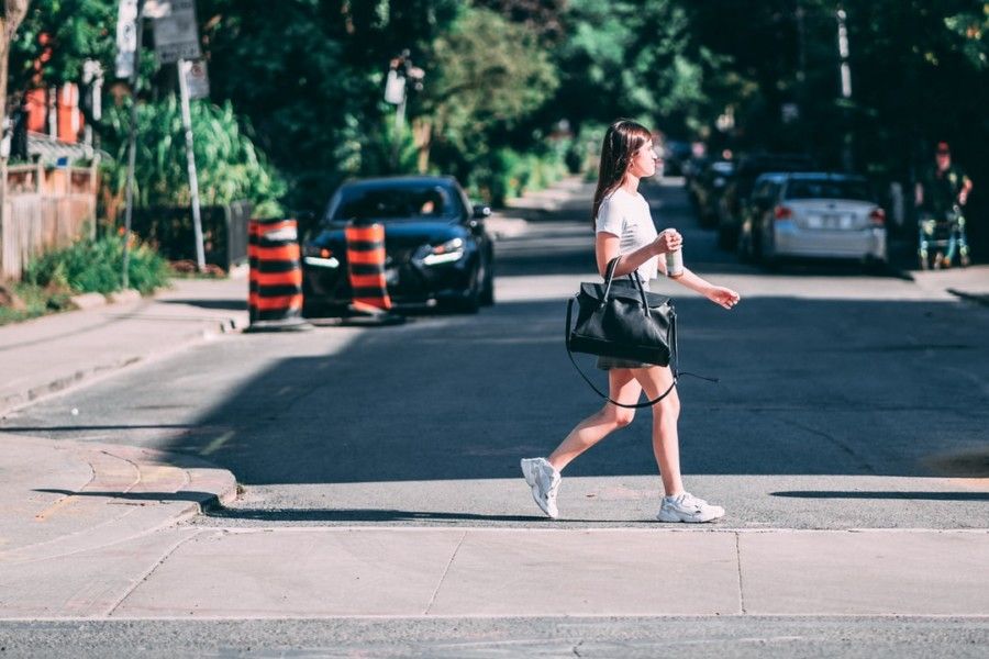 woman-holding-bag-walking-on-pavement