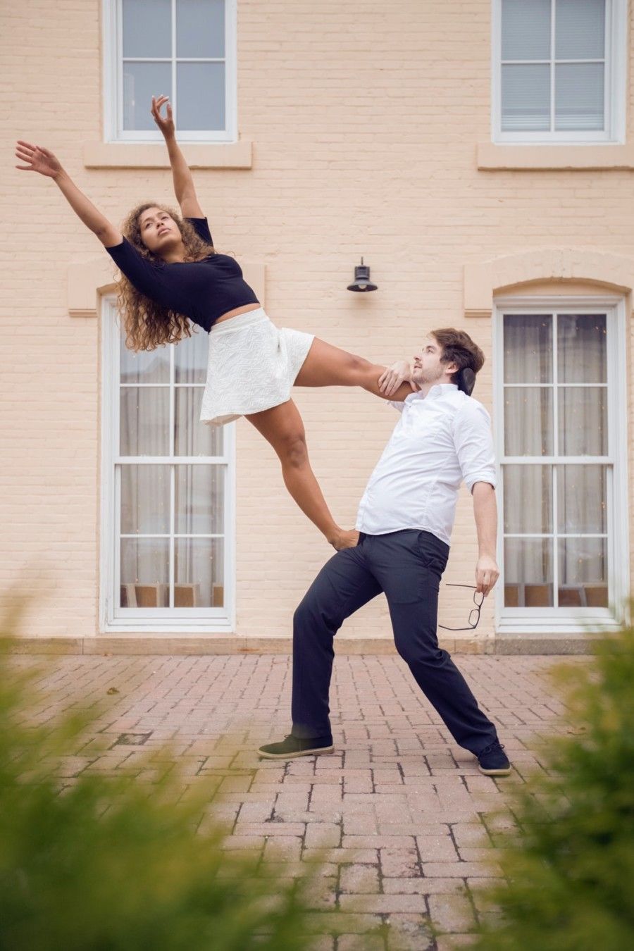 woman-stepping-on-man-while-posing-near-building-during-daytime