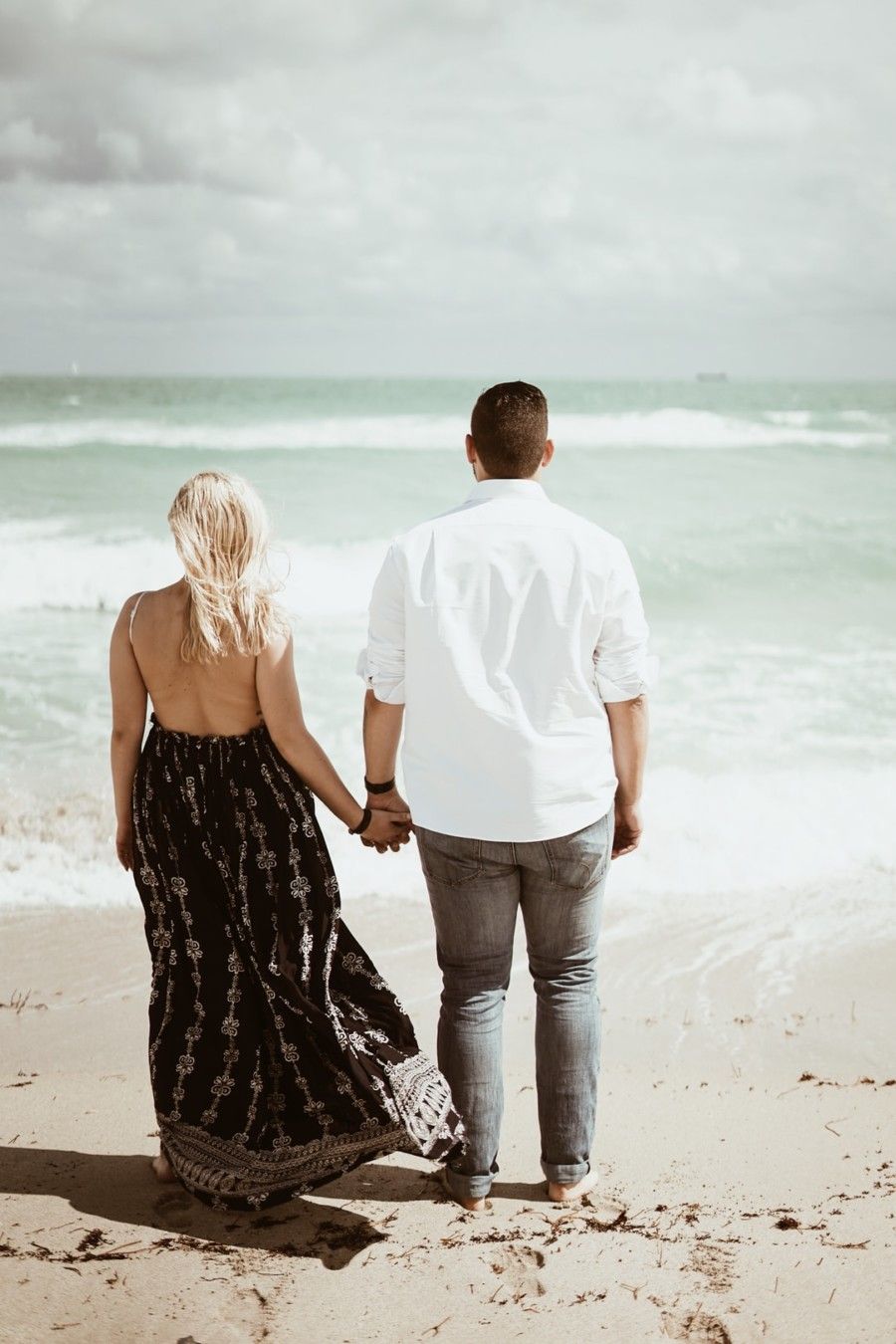 man-and-woman-holding-each-others-hands-and-walking-by-the-seashore-during-daytime