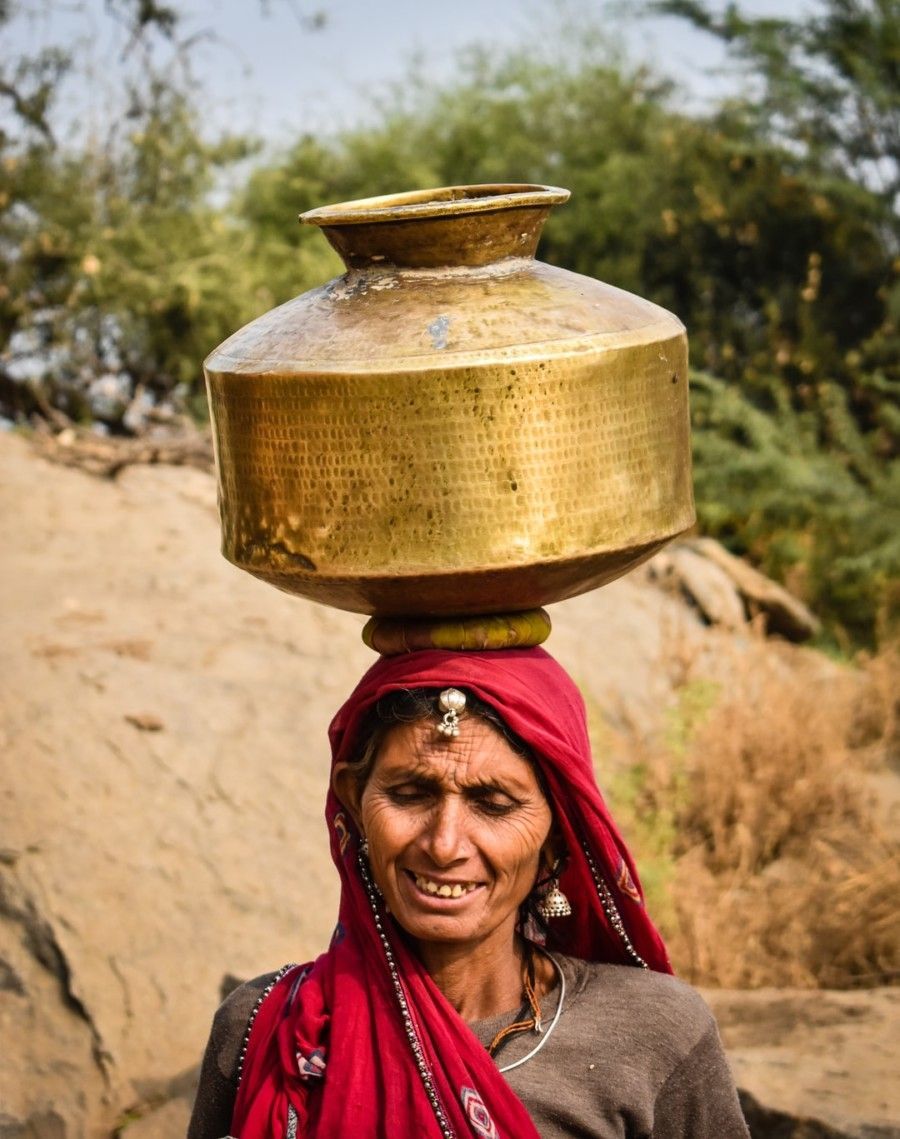 woman-carrying-gold-jar-on-head