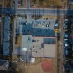 aerial-photography-of-large-building-with-vehicles-on-parking-lot-during-daytime