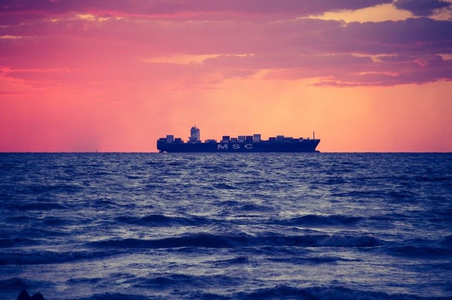 black-ship-on-calm-sea-during-golden-hour