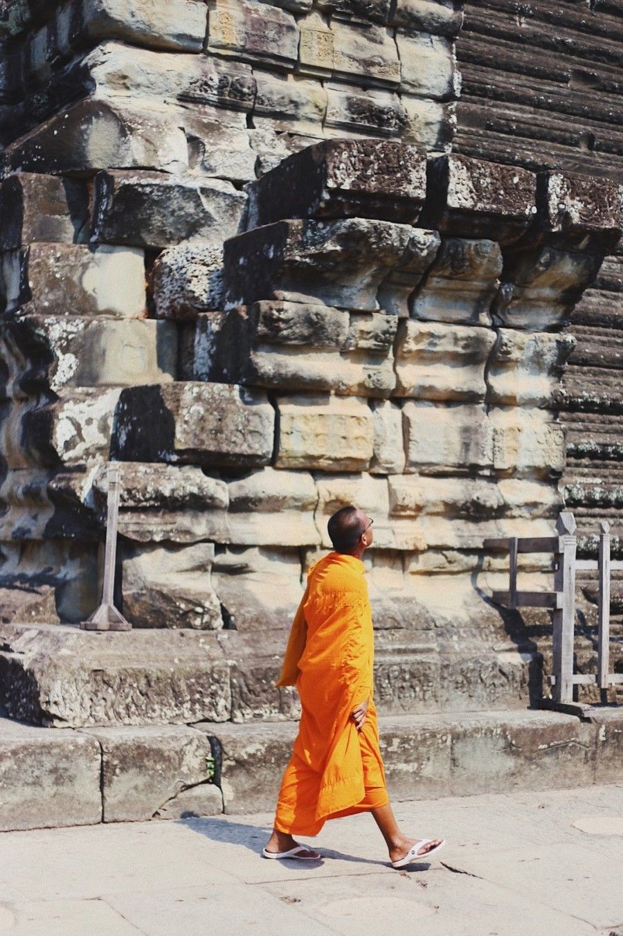 monk-walking-along-sidewalk-while-looking-up